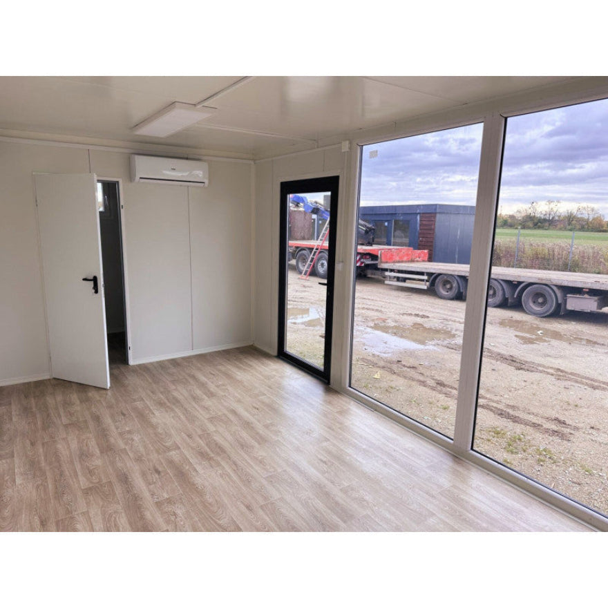 Contenedor elevado 7×3 m con grandes vitrinas, aire acondicionado y baño – módulo prefabricado tipo oficina o showroom